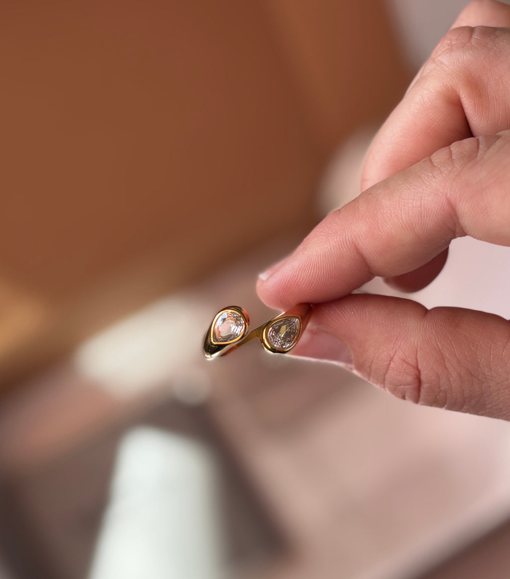 Anillo dorado con circonitas en la mano