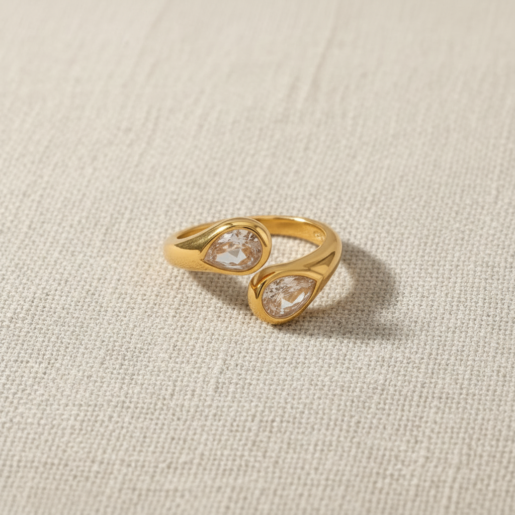 Anillo dorado ajustable con circonitas sobre fondo beige