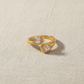 Anillo dorado ajustable con circonitas sobre fondo beige